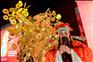 1月9日，在馬來西亞吉隆坡，一名裝扮成財神爺的演員與“富貴黃金樹”合影。